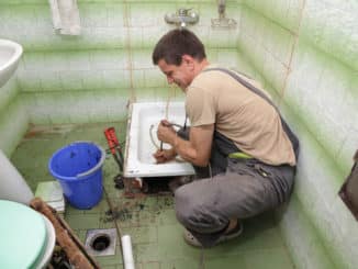 Handwerker reinigt verstopften Duschabfluss